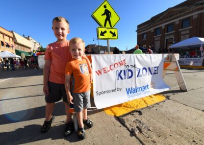 Two children standing in front of the Kid Zone at Thursday Night Music