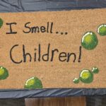 a welcome mat that says "I smell children"