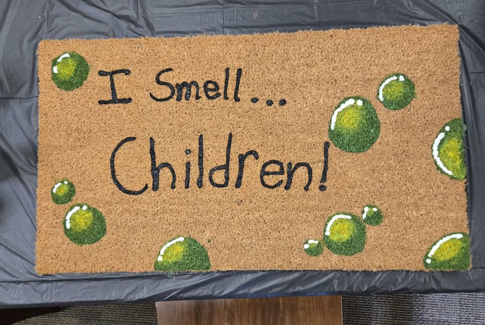 a welcome mat that says "I smell children"