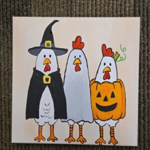 A canvas painting of three chickens in Halloween costumes