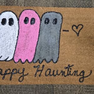 A doormat with three ghosts painted on it and the words "Happy Haunting"